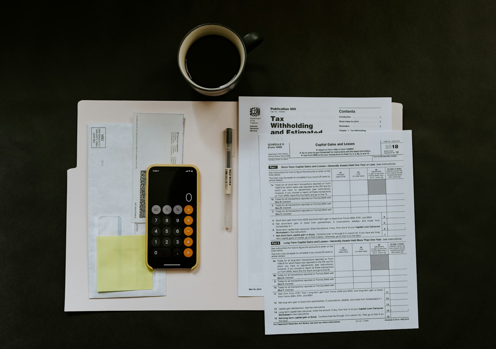 Accounting ledgers and a calculator beside a laptop