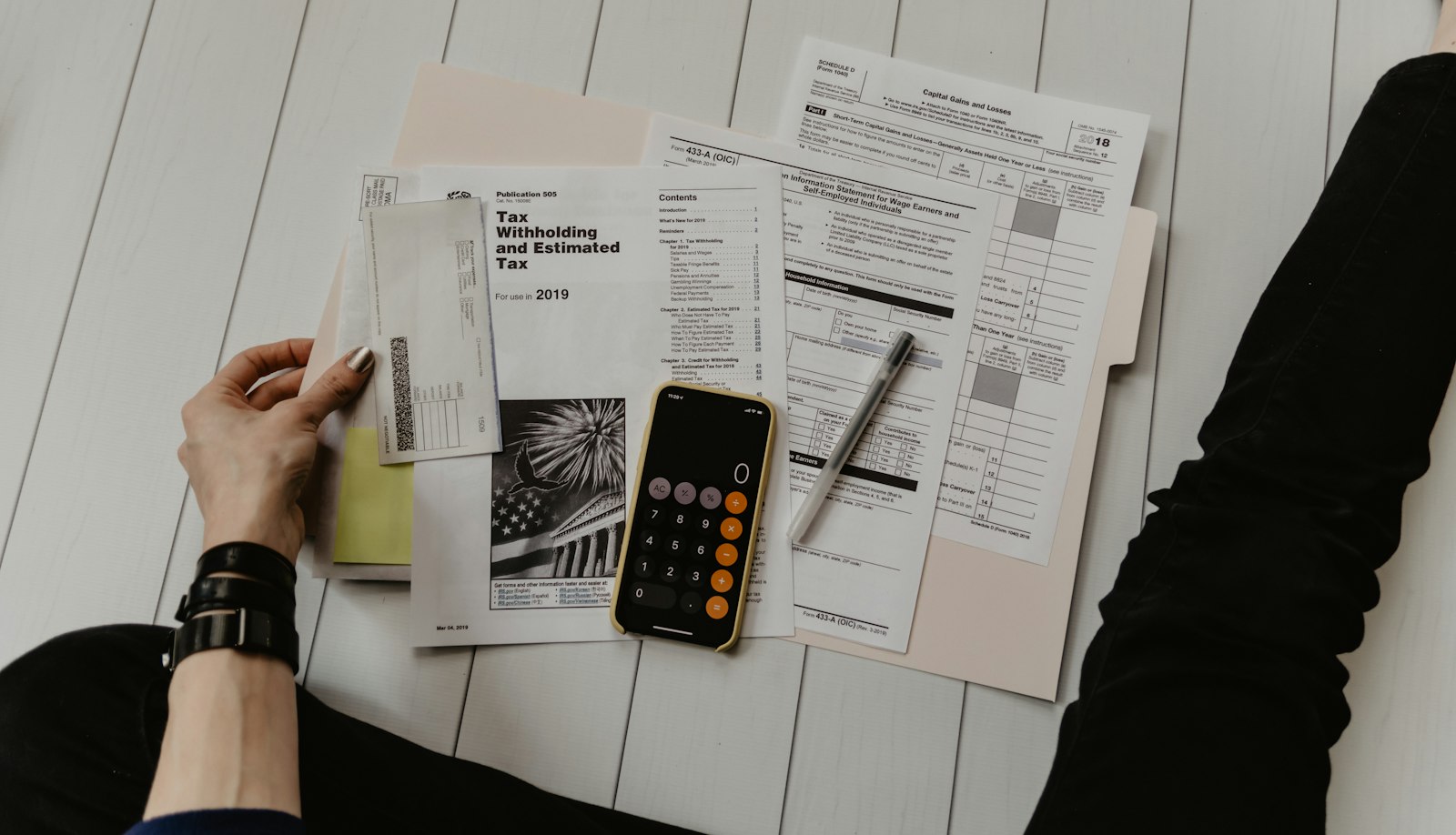 Calculator and financial paperwork on a wooden desk