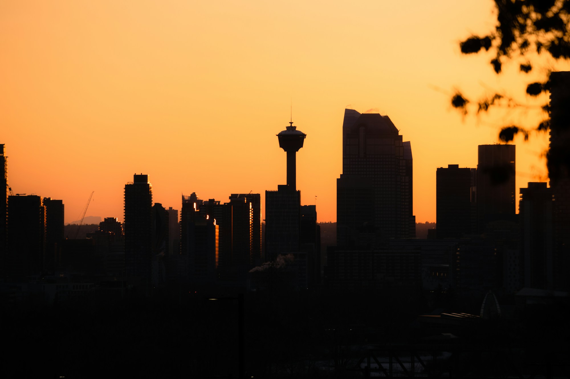 Calgary skyline silhouetted at sunset, with the Calgary Tower visible